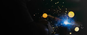A person is welding with sparks flying from their hands.